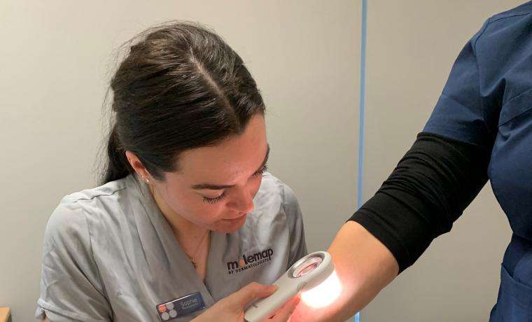 MoleMap melanographer Sophie Hall checks for melanomas on the arm of Maree McFarlane, the site coordinator of the trial at Bass Coast Health.