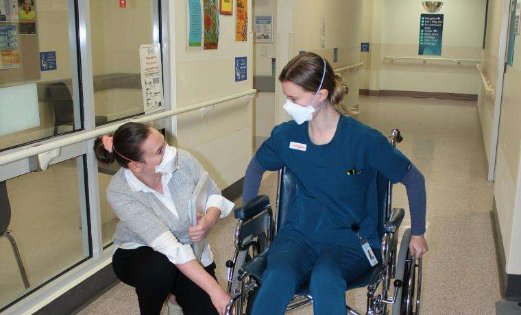 Clinical Development Occupational Therapist Jenna Davis (left) discusses wheelchair setup with Graduate Occupational Therapist Miriam Ceff at Wonthaggi Hospital.