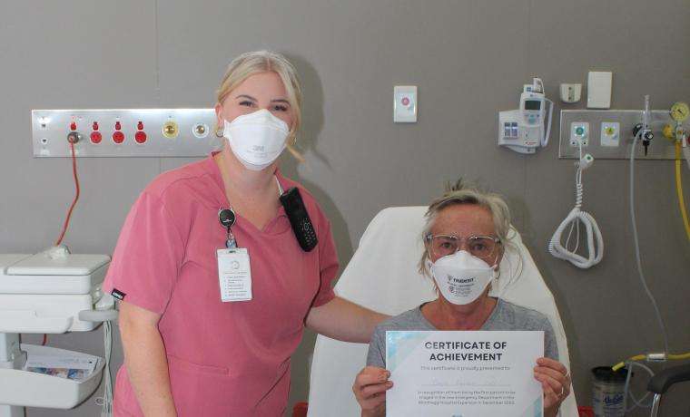 Emergency Department Acting Nurse Unit Manager Cat Bunn with the first patient to be treated in the new ED, Chris Larsen of Phillip Island. She received a certificate to mark the occasion.