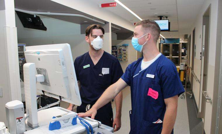 Novice Workforce Clinical Development Nurse Liam Kennedy, right, chats with Graduate Nurse Matthew Pearce in the Short Stay Unit at Wonthaggi Hospital.