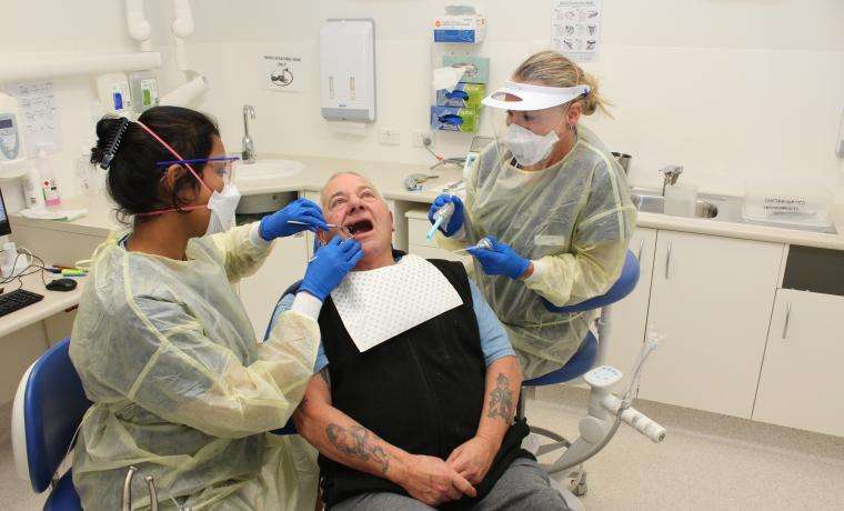 Patient Les McLean receives treatment at Bass Coast Health’s dental service at Wonthaggi Hospital from Dentist Dr Roshine Linus and Dental Assistant Karina Theisinger.