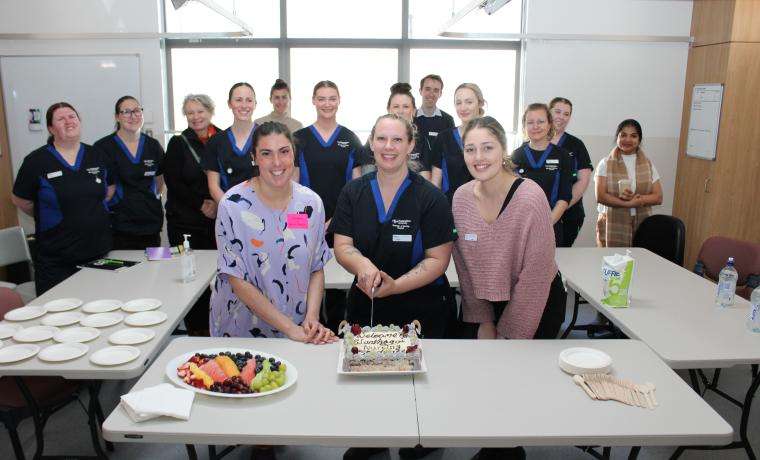 New Nursing student Lucy Veal (centre) with Bass Coast Health staff members Sarah Hogan and  Gabrielle O’Connor cut a cake to mark the first intake of nursing students at BCH. They are with fellow  students, Andrea Evans-McCall from Country Universities Centre Bass Coast and Ligi Anish from  Federation University