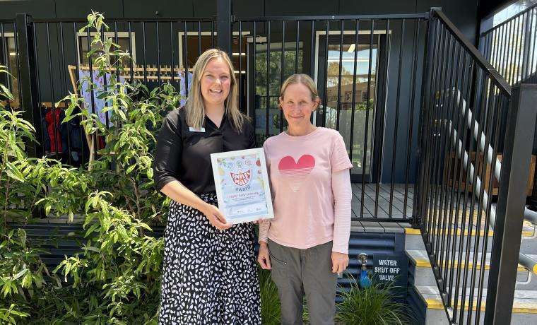 Beth (Smiles 4 Miles Coordinator, South Coast Prevention Team) presenting the Smiles 4 Miles award to Amy (Early Childhood Teacher, Foster Early Learning).