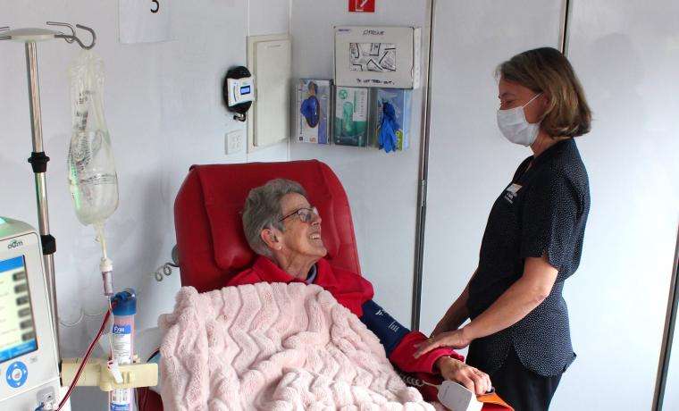 Patient Carmel Sampson receives dialysis on-board the Big Red Kidney Bus with Haemodialysis Nurse Stacey.