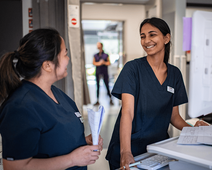 Nurses at workstation discussing patient